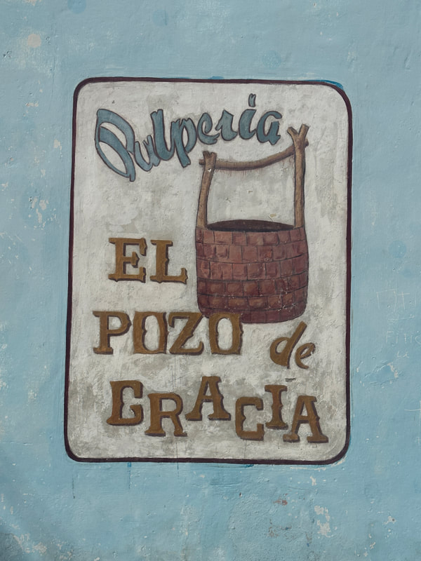 A sign painted on a wall.  Text in Spanish. 