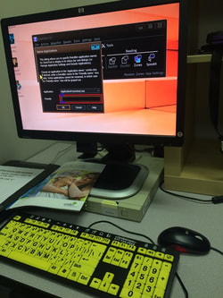 Picture of a compute with high contrast keyboard and screen magnification software on screen.