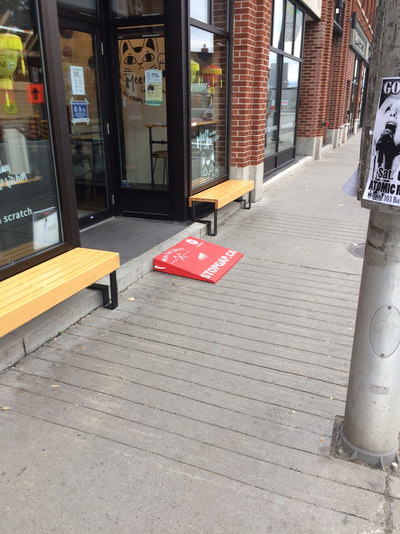 A small mobile ramp on sidewalk leading into store.