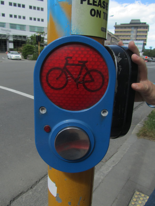 Pedestrian crossing button with red signal light.