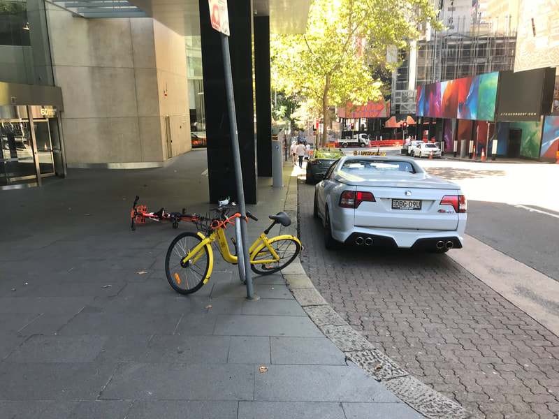 Bicycles laying on sidewalk.